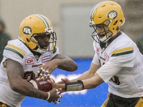Edmonton Eskimos quarterback Mike Reilly hands off to C.J. Gable during first half CFL football action against the Montreal Alouettes in Montreal, Monday, October 9, 2017.