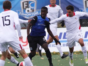 FC Edmonton midfielder Abraham Dukuly, centre, dribbles the ball between three members of the San Francisco Deltas in North American Soccer League play at Clarke Stadium on Sunday, Oct. 1, 2017.