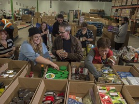 A group of 12 volunteers, pictured on Thursday, Oct. 5, from Starbucks coffee shops around Edmonton take a regular volunteer shift at the Food Bank. Volunteering is one potential strategy to combat social isolation, says a new report.