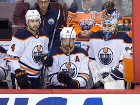 Edmonton Oilers' goalie Cam Talbot, right, sits on the bench next to Kris Russell (4) and Adam Larsson, of Sweden, after being pulled from the game after allowing a third goal to the Vancouver Canucks during the second period of an NHL hockey game in Vancouver, B.C., on Saturday, October 7, 2017.