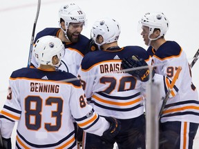 From left, Edmonton Oilers players Matthew Benning, Patrick Maroon, Leon Draisaitl and Connor McDavid celebrate Draisaitl's goal against the Vancouver Canucks during the first period of a preseason NHL hockey game in Vancouver, B.C., on September 30, 2017.