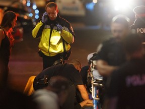 Paramedics work on one of the pedestrians struck down in an alleged terror attack on Jasper Avenue on Saturday, Sept. 30, 2017.