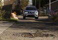 A pothole collects fallen leaves in an alley near 83 Street and 80 Avenue in Ward 11 in Edmonton, Alberta on Monday, October 9, 2017. Ian Kucerak / Postmedia