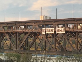 Activists dropped a 50-foot-wide banner from the High Level Bridge Friday morning to protest a proposed pipeline expansion through British Columbia