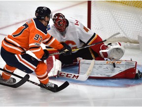 Edmonton Oilers Connor McDavid (97) goes in on Calgary Flames goalie Mike Smith who makes the save during the season opener of NHL action at Rogers Place in Edmonton, October 4, 2017.