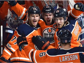 Edmonton Oilers Connor McDavid (97) celebrates with Oscar Klefbom (77) and Leon Draisaitl (29) his first goal of the game against the Calgary Flames during the season opener of NHL action at Rogers Place in Edmonton, October 4, 2017.