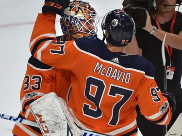 Edmonton Oilers star Connor McDavid, who scored a hat-trick in the game, congratulates goalie Cam Talbot on his shutout performance against the Calgary Flames during the season-opener of NHL action on Oct. 4, 2017, at Rogers Place in Edmonton.