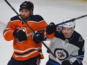 Edmonton Oilers Patrick Maroon (19) and  Winnipeg Jets Jacob Trouba battle it out during NHL action at Rogers Place in Edmonton, October 9, 2017.