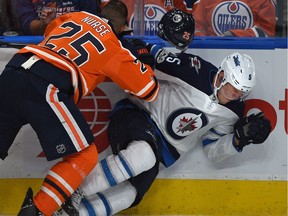 Edmonton Oilers Darnell Nurse (25) loses his helmet as he collides with Winnipeg Jets Dmitry Kulikov during NHL first period action at Rogers Place in Edmonton, October 9, 2017.