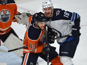 Edmonton Oilers defenceman Matthew Benning, left, and Winnipeg Jets forward Bryan Little in front of Oilers net during NHL action at Rogers Place in Edmonton on Oct. 9, 2017.