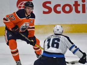 Edmonton Oilers Connor McDavid (97) trying to pass the puck through Winnipeg Jets Shawn Matthias during NHL action at Rogers Place in Edmonton, October 9, 2017.