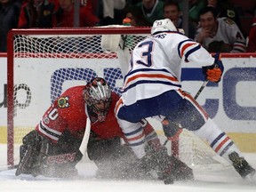Chicago Blackhawks goalie Corey Crawford (50) stops the shot of Edmonton Oilers center Ryan Nugent-Hopkins (93) during the first period of an NHL hockey game Saturday, Feb. 18, 2017, in Chicago.