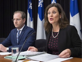 Quebec Justice Minister Stephanie Vallee provides further details about how the government's controversial Bill 62 will be implemented at the legislature, as Justice Minister Yan Paquette, left, looks on in Quebec City Tuesday, Oct. 24, 2017. The law bans people from giving or receiving public services if their face is covered.