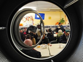 Diners at the 20th annual Thanksgiving dinner, shown in a photograph taken from the inside of a laundromat dryer, at the Millbourne Laundromat in Edmonton on Oct. 14, 2013.