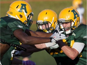 Shaydon Phillip,, left, and Ryan Migadel (24) take part in an Alberta Golden Bears football camp practice at Foote Field, in Edmonton on Monday Aug. 15, 2016.