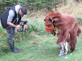 Haida Gwaii carver Ben Davidson plays the role of a bear while shooting a musical video at Skedans, a former trading post with ancient totem poles and now part of the Gwaii Haanas National Park Reserve and Haida Heritage Site.