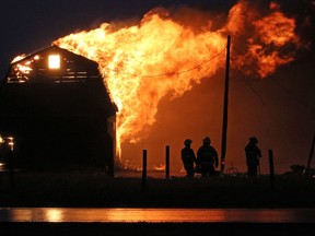 Rockyview County firefighters deal with a barn that was ignited in a wind driven grass fire south of Airdrie on Tuesday afternoon October 17, 2017.