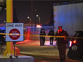 Police on the scene where a male body was found behind this trailer next to the yard of Alberta Plywood at 9923 65 Ave. Police were following a trail along the railway track behind the building in Edmonton on Nov. 19, 2017.