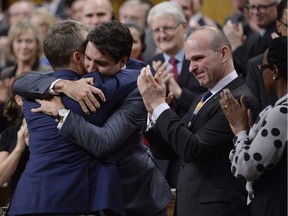 Prime Minister Justin Trudeau hugs Veteran's Affairs Minister Seamus O'Regan after making a formal apology to individuals harmed by federal legislation, policies, and practices that led to the oppression of and discrimination against LGBTQ2 people in Canada, in the House of Commons in Ottawa on Tuesday, Nov. 28, 2017.