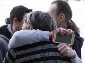 Serenity's mother (holding the phone) is hugged by a supporter outside the court house in Wetaskiwin Thursday Nov. 9, 2017.