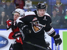 Darian Skeoch of the Vancouver Giants checks Jackson Leppard of the Prince George Cougars during the third period of their WHL game at the Langley Events Centre on October 27, 2017 in Langley, British Columbia, Canada.