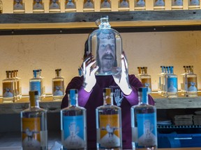 Adam Smith, owner of the Strathcona Spirits distillery in Edmonton on Nov. 17, 2017. He is photographed through a mason jar and behind him are bottles of the gin and vodka his company produces.