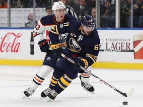 Benoit Pouliot #67 of the Buffalo Sabres skates with the puck as Ryan Nugent-Hopkins #93 of the Edmonton Oilers pursues during the second period at the KeyBank Center on November 24, 2017 in Buffalo, New York.