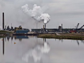 The Syncrude oil sands extraction facility is reflected in a tailings pond near the city of Fort McMurray, Alta., on June 1, 2014.