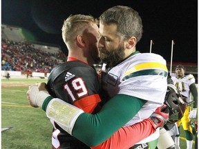 Stamps QB Bo Levi Mitchell (L) and Eskimos QB Mike Reilly hug following the CFL Western Final in Calgary between the Calgary Stampeders and the Edmonton Eskimos on Sunday, November 19, 2017. The Stamps will meet Toronto Argonauts in the Grey Cup.