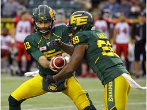Edmonton Eskimos quarterback Mike Reilly (left) hands off the ball to running back C.J.Gable during Canadian Football League game action against the Calgary Stampeders in Edmonton on Saturday October 28, 2017.