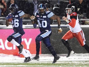 Calgary Stampeders quarterback Bo Levi Mitchell, right, chases Toronto Argonauts defensive back Cassius Vaughn, left, and Shawn Lemon after a fumble recovery during second half CFL football action in the 105th Grey Cup on Sunday, Nov. 26, 2017 in Ottawa.