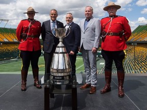 Edmonton Eskimos President and CEO, Len Rhodes, second from the right, poses with the Grey Cup on June 5, 2017