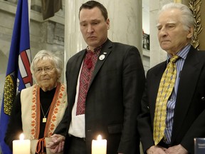 MLA Jessica Littlewood, Holodomor survivor Natalia Talanchuk and Olesia Luciw-Andryjowycz light candles during the Holodomor commemoration ceremony held at the Alberta legislature in Edmonton on Tuesday, Nov. 22, 2016
