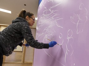 Carla Rae Taylor paints the first mural for the Canada 150 Paint the Rails legacy project in collaboration with the John Humphrey Centre for Peace and Human Rights and the Edmonton Transit Service at Churchill LRT Station in Edmonton, Alta., on Sunday, Nov. 19, 2017.
