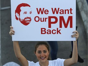 A Lebanese woman holds a placard supporting the outgoing Lebanese Prime Minister Saad Hariri to return from Saudi Arabia during the Beirut Marathon, in Beirut, Lebanon, Sunday, Nov. 12, 2017. Absent from the marathon this year is Hariri, a regular participant, who resigned from his post unexpectedly last week while in Saudi Arabia. The country's President Michel Aoun urged runners to call on the prime minister to return home.