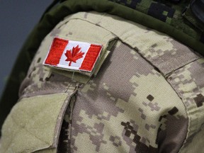 A Canadian flag patch is shown on a soldier's shoulder.