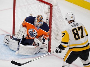 Edmonton Oilers goalie Cam Talbot (33) stops the puck as Pittsburgh Penguins Sidney Crosby (87) watches during second period NHL action on Wednesday November 1, 2017, in Edmonton.