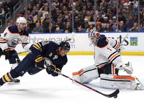 Evander Kane #9 of the Buffalo Sabres tries to knock the puck past Laurent Brossoit #1 of the Edmonton Oilers as Kris Russell #4 defends during the second period at the KeyBank Center on November 24, 2017 in Buffalo, New York.