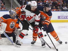 New Jersey Devils' Adam Henrique (14) and Edmonton Oilers' Jussi Jokinen (36) jostle in front as Oilers goalie Cam Talbot (33) looks for the puck during third period NHL action in Edmonton on Friday, November 3, 2017.