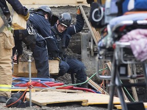 Emergency crews work at the scene of a trench collapse that killed Fred Tomyn on 123 Street near 107 Avenue in Edmonton on Tuesday, April 28, 2015.