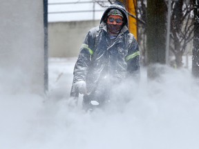 A man clears snow in Calgary on Nov. 16, 2017.