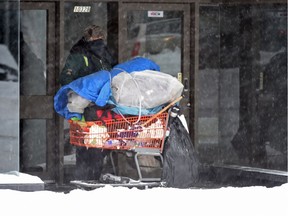 A homeless man shelters in a business doorway on Jasper Avenue in Edmonton on Friday, Nov. 28, 2014.