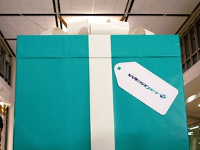 A more than three-metre tall present awaits passengers travelling with WestJet to Abbotsford, B.C., from Edmonton International Airport on Thursday, Nov. 23, 2017. Passengers ripped away layers of gift wrap offering increasingly valuable prizes before opening the last box, revealing a free flight voucher for each scheduled passenger on the flight as part of WestJet's 12 Flights of Christmas holiday campaign, promising 12 surprises in 12 Canadian cities.
