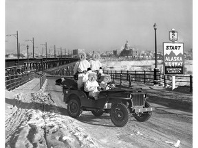 U.S. Army engineers building the Alaska Highway pose by an ice-covered High Level Bridge.