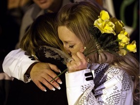 Tracy Stark, right, is embraced by a woman during a candlelight vigil for her sons Radek MacDougall, 11, and Ryder MacDougall, 13, in Spruce Grove on Dec. 22, 2016. The two boys were found dead in their Spruce Grove home on Monday Dec. 19, 2016.