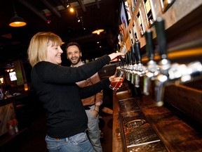 Andrea Taylor serves herself a drink during the launch party for Urban Tavern's self-serve beer wall in Edmonton on Friday, Dec. 22, 2017.