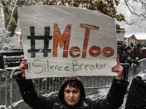 NEW YORK, NY - DECEMBER 09: People carry signs addressing the issue of sexual harassment at a #MeToo rally outside of Trump International Hotel on December 9, 2017 in New York City.