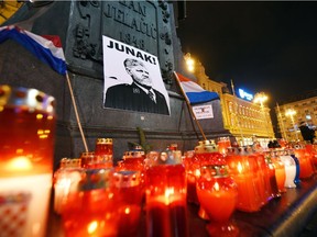 Lit candles and flags are placed in tribute to General Slobodan Praljak in Zagreb on November 30, 2017, after the Bosnian Croat war criminal took his own life in front of United Nations war crimes judges, apparently drinking poison just after they upheld his 20-year jail term for atrocities committed during the Balkans conflict.  Croatia's president said on November 30 that citizens had to admit crimes were committed by fellow Croats during the 1990s conflict in Bosnia, a day after a Bosnian Croat war criminal took his own life at a court in The Hague.