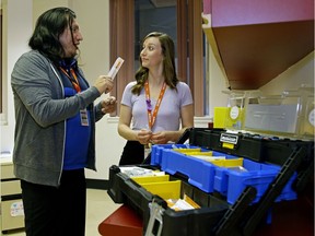 Addiction Recovery Community Health (ARCH) team members Robert Gurney, left, and Kelsey Speed discuss the contents of  a harm reduction kit at Royal Alexandra Hospital.