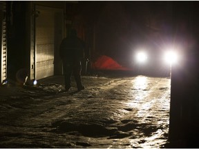 A police officer protects a crime scene in a back alley near 83 avenue and 97 street on Wednesday December 6, 2017 in Edmonton.